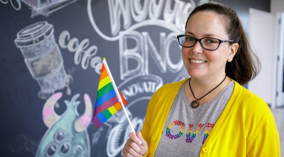 Theresa holding a Pride flag.