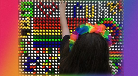 Juniper placing pegs in a multi-color LED board.