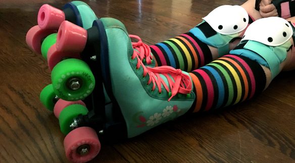 Green roller skates with rainbow socks.