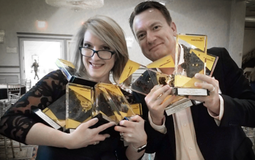 Trista Walker and George Jackus holding multiple awards.