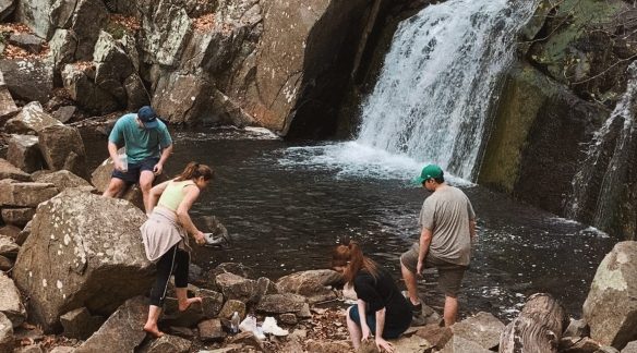 The BNO Hiking Club enjoying an outdoor hike with a waterfall in the background.