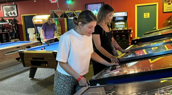 Two BNO staff members playing pinball.